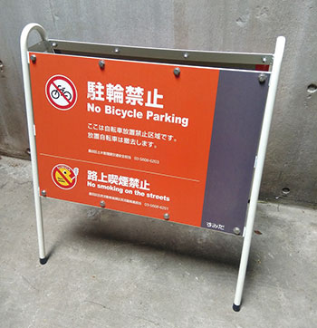 違法駐輪禁止兼路上喫煙禁止の啓発看板（オレンジ色）