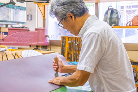 中野代表が革の裁断を行っている様子の写真